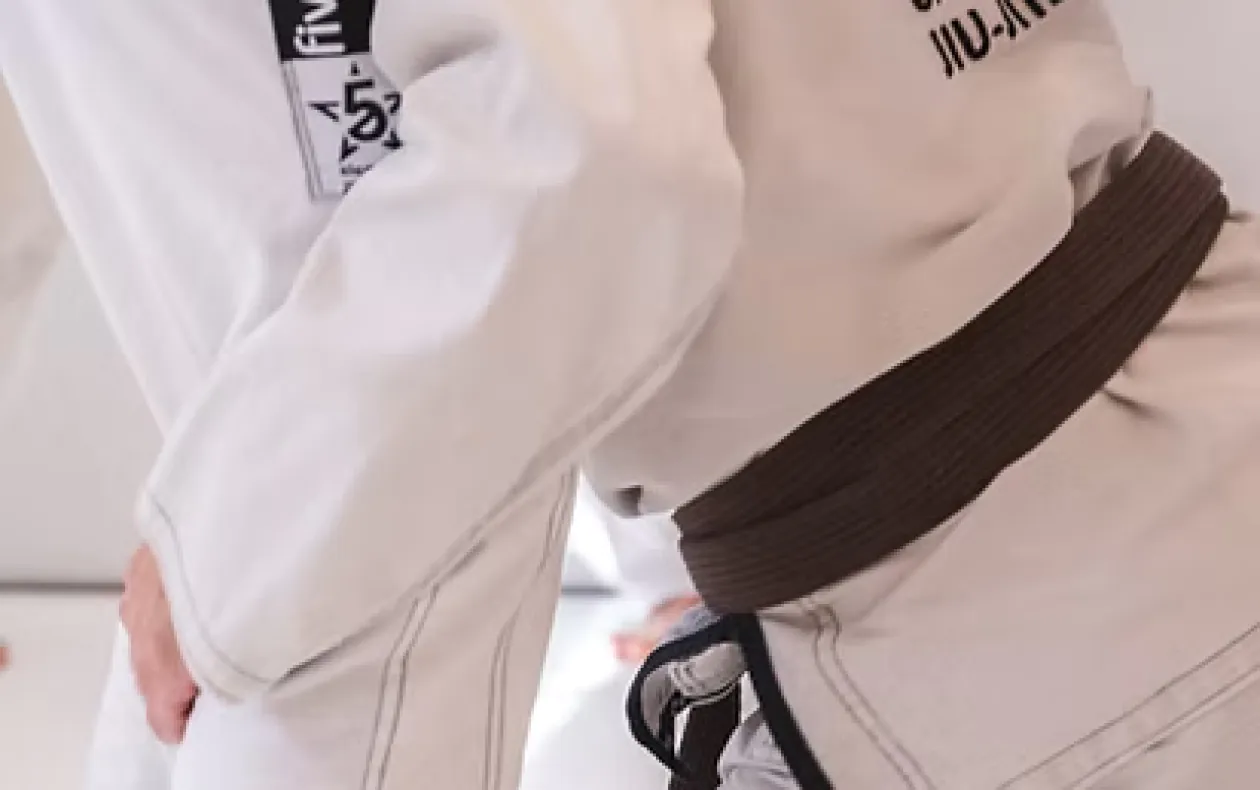 Man meditating on yoga mat recording with phone.